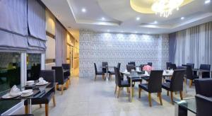 a dining room with tables and chairs in a restaurant at Phuglong Hotel in Phayao