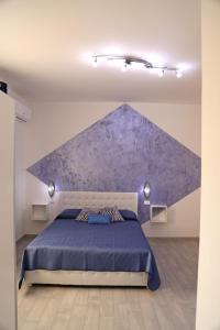 a bedroom with a bed with a purple wall at B&B Mimì in Castelsardo