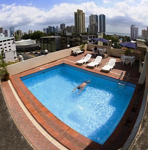 a person swimming in a swimming pool on top of a building at Hotel Montreal in Panama City
