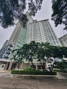 un grand bâtiment avec des arbres devant lui dans l'établissement 1203BT3 Solinea Resort Condo Unit Queen Bed Ayala Center, à Cebu