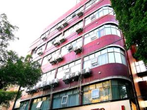 a tall red building with windows and plants at Shell Ganzhou Central Theme Hotel in Ganzhou