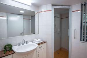 a white bathroom with a sink and a shower at Nautilus 1 - 1- 46 Lawson Street in Byron Bay +6 photos