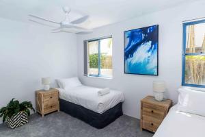 a bedroom with a bed and two windows at Nautilus 1 - 1- 46 Lawson Street in Byron Bay
