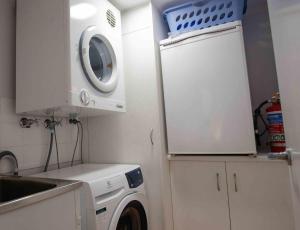a laundry room with a washing machine and a sink at Nautilus 1 - 1- 46 Lawson Street in Byron Bay