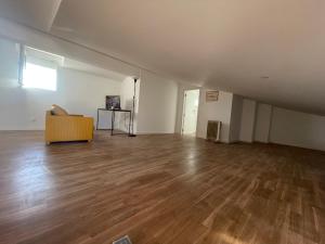 een lege woonkamer met een bank en houten vloeren bij You have to love Amarante in Amarante