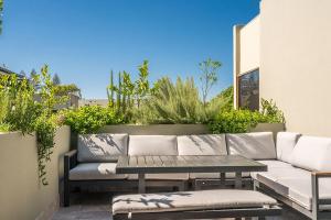 a patio with a couch and a table and plants at A Seventh Summer - 5 21-25 Fletcher Street in Byron Bay