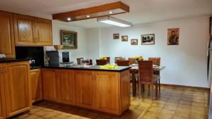 a kitchen with wooden cabinets and a table with chairs at Charming Villa in Moniatis, Cyprus - Private Pool Garden in Saittas
