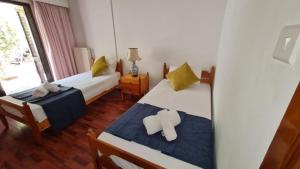 a bedroom with two beds with yellow pillows at Charming Villa in Moniatis, Cyprus - Private Pool Garden in Saittas