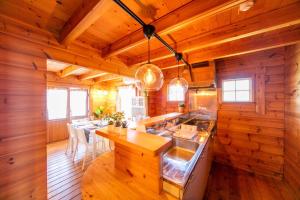 a kitchen with wooden walls and a dining room with tables at [Sumoto City] Log house Gosyokumachi1 - Vacation STAY 14162 in Sumoto