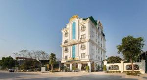 a white building with blue windows on a street at Chin Luc Hotel in Ðồng Phú