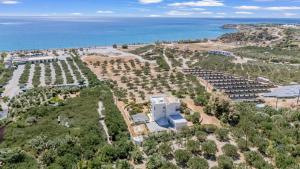 une vue aérienne d'un bâtiment et de l'océan dans l'établissement Almyra Resort, à Koutsounari