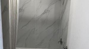 a shower with a glass door with a marble shower curtain at Scottish Inns Augusta in Augusta +54 photos
