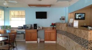 a kitchen with a bar with a table and a tv at Scottish Inns Augusta in Augusta