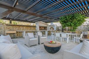 Elle comprend une terrasse dotée d'un mobilier blanc, d'une table et de chaises. dans l'établissement Almyra Resort, à Koutsounari