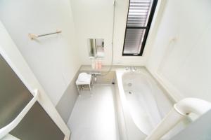 Un baño blanco con bañera y lavabo. en Ａｗａｊｉ Ｓｅａｓｉｄｅ Ｒｅｓｏｒｔ ｉｎ Ｉｋｕｈａ - Vacation STAY 77513v, en Awaji 39 fotos más