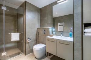 a bathroom with a toilet and a shower and a sink at Luxury Suite with Sea & PANORAMA View - Alliance Palace in Batumi