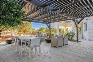un patio avec une table et des chaises sous une pergola dans l'établissement Almyra Resort, à Koutsounari