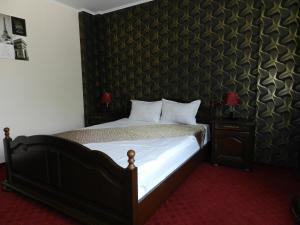 een slaapkamer met een bed met een zwarte muur bij Hotel Marinii in Boekarest