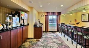 a restaurant with a bar with stools at AmericInn by Wyndham Oshkosh in Oshkosh