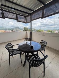 a table and chairs on a balcony with a view at Reva suites in Arsikere