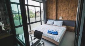 una piccola camera da letto con un letto e una sedia di The Smart Hostel a Nakhon Ratchasima