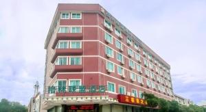 a tall red building with a sign on it at GreenTree Alliance Zhejiang Zhoushan Putuoshan Zhujiajian Scenic Spot Hotel in Zhoushan