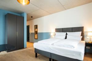 1 dormitorio grande con 1 cama grande con sábanas blancas en Das Adler, en Markdorf