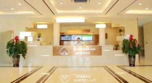 a lobby of a store with two potted plants at GreenTree Inn Yichun Qingshan Street Express Hotel in Jiamusi