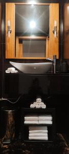 a bathroom with a sink and a shelf with towels at Pico Blue Ocean - Sea House in São Roque do Pico