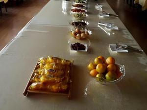 a table with bowls of fruit and desserts on it at GreenTree Inn Langfang GuAn County Xinyuan Street Express Hotel in Langfang