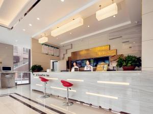 a restaurant with red stools in front of a counter at GreenTree Inn Nantong University Industrial Expo City Express Hotel in Nantong