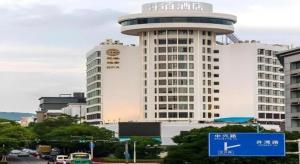 a large white building with a sign in front of it at Chambery Hotel in Zhuhai