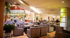 a restaurant with tables and chairs and people in it at Tianjin Juchuan Lily Hotel in Binhai