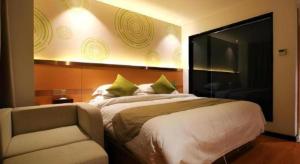 a bedroom with a large bed and a chair at GreenTree Inn Fuzhou Gulou District West Xierhuan Road Zuohai Park in Fuzhou +153 photos