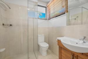 a bathroom with a toilet and a sink and a shower at Lakeside Bliss in Dunbogan +22 photos