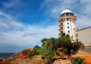 a lighthouse on a cliff next to the ocean at Villa Senu in Ambalangoda