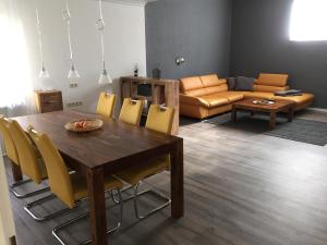 een woonkamer met een tafel en stoelen en een bank bij Ferienwohnung Würzburg Sanderau in Würzburg