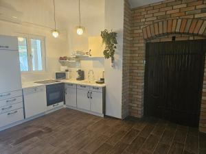 una cucina con armadietti bianchi e una porta nera di Marina Cottage a Enying Altre 7 foto