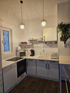 una cucina con lavello e microonde di Marina Cottage a Enying