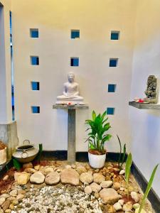 a buddha statue sitting on a table in a room at Villa Solara Bay in Ambalangoda