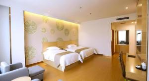 a bedroom with two beds and a couch at GreenTree Inn Xi'an Terracotta Warriors Huaqing Pool Metro Station in Xi'an