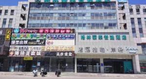 a large building with signs on the side of it at GreenTree Inn Beijing Shunyi Fengbo Metro Station in Beijing