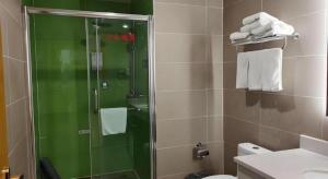 a bathroom with a shower with a glass door at GreenTree Inn Xi'an Terracotta Warriors Huaqing Pool Metro Station in Xi'an