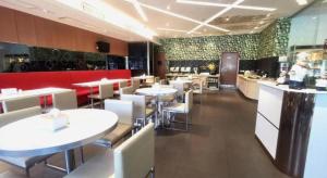a restaurant with white tables and white chairs at Zhangye Pinmu Hotel(Yuncheng Zhongyin Avenue Store) in Yuncheng