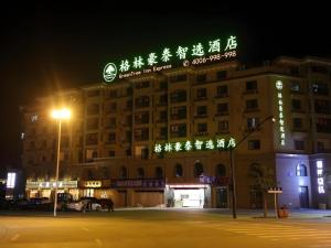 a building with neon signs on it at night at GreenTree Inn Jiaxin Puyuan Kaixuan Road in Jiaxing