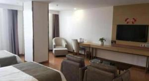 a hotel room with a bed and a desk and a television at GreenTree Inn Huhehaote Tumote Left Flag Branch in Hohhot