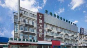 a building with a sign on the side of it at GreenTree Inn Yancheng Yandu District Hongxing Macalline Century Avenue in Yancheng
