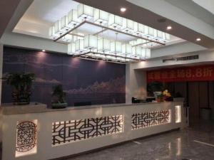 a lobby with a reception desk with a painting on the wall at Kyriad Marvelous Hotel Xiangyin Bus Station in Xiangyin
