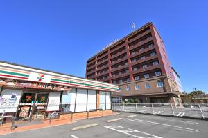 a tall building next to a parking lot next to a street at Hotel nanvan Yaizu in Yaizu