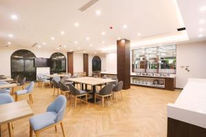 a restaurant with tables and chairs in a room at GEM Hotel Ningbo Jiangbei District Hongtang Haide Square in Kao-ch'iao